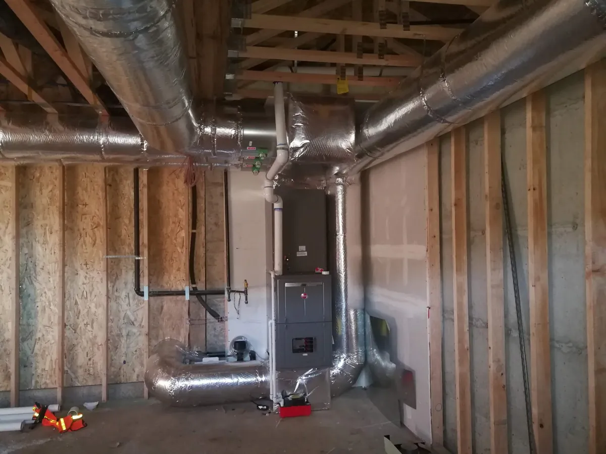 Rheem furnace install with silver duct on a residential jobsite